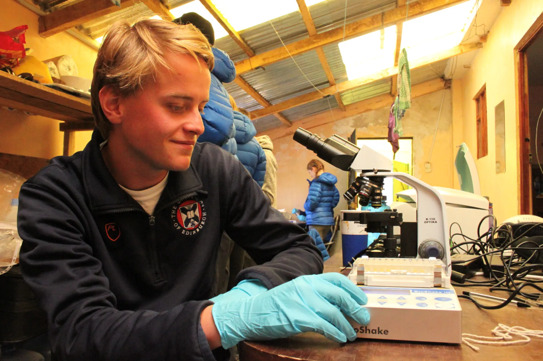 Student looking through microscope. 