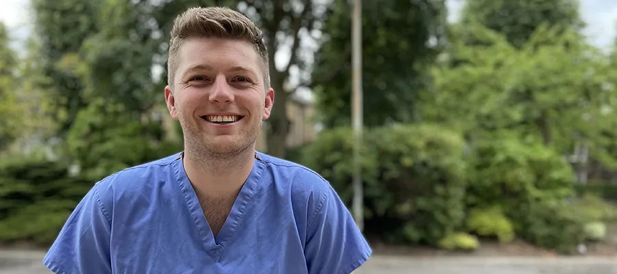 Medical graduate outside wearing scrubs