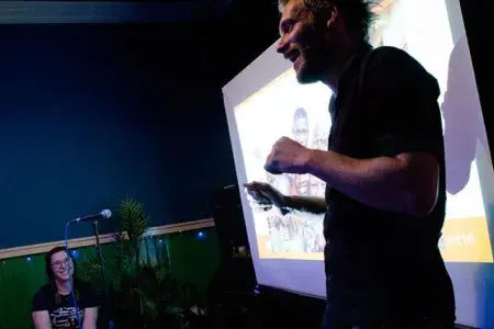 A speaker stands in front of presentation screen